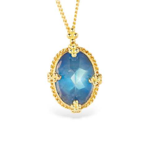 Gold necklace with a moonstone pendant on a white background