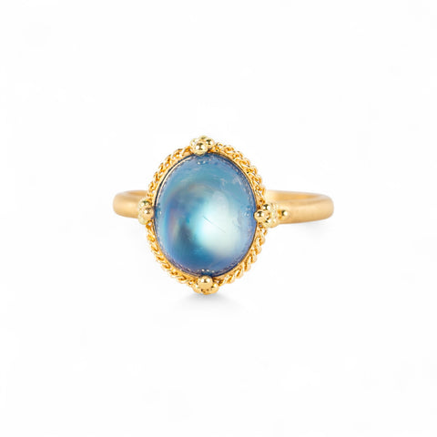 Gold ring with a moonstone gemstone on a white background