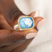 Gold and silver ring with a moonstone held in hand
