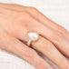 Gold and silver ring with pink morganite teardrop-shaped gemstone on a hand