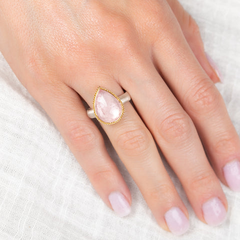Gold and silver ring with pink morganite teardrop-shaped gemstone on a hand
