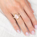 Gold and silver ring with pink morganite teardrop-shaped gemstone on a hand