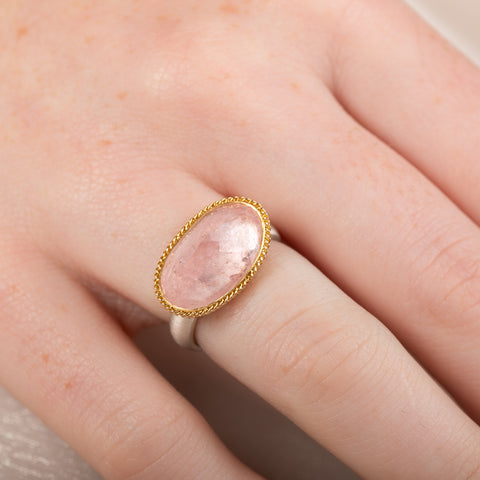 Ring with morganite stone, gold bezel and silver band on a person's finger