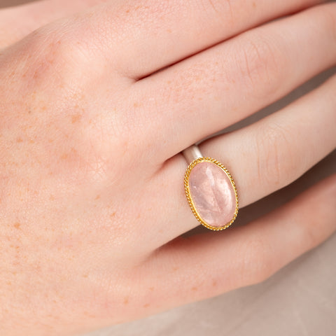 Ring with morganite stone, gold bezel and silver band on a person's finger