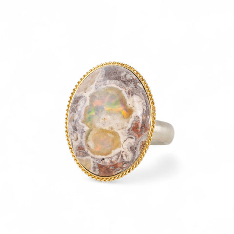 Handmade ring with a Mexican Opal stone set in an 18k gold bezel with a sterling silver band