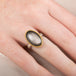 Obsidian ring with gold setting and silver band on a person's finger