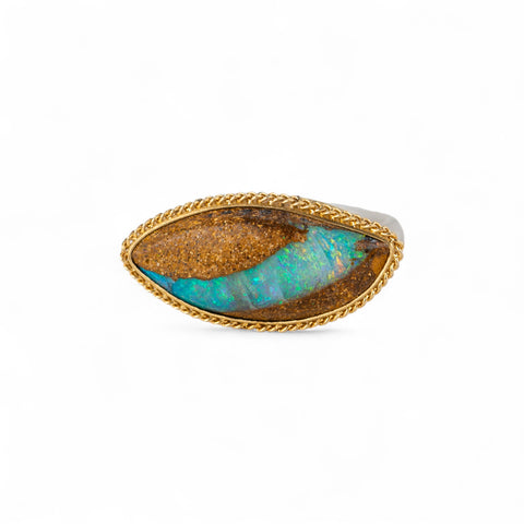 Ring with an opal stone, gold setting and silver band on a white background
