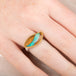 Ring with an opal stone, gold setting and silver band on a hand