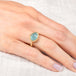 Gold ring with an aquamarine gemstone on a hand