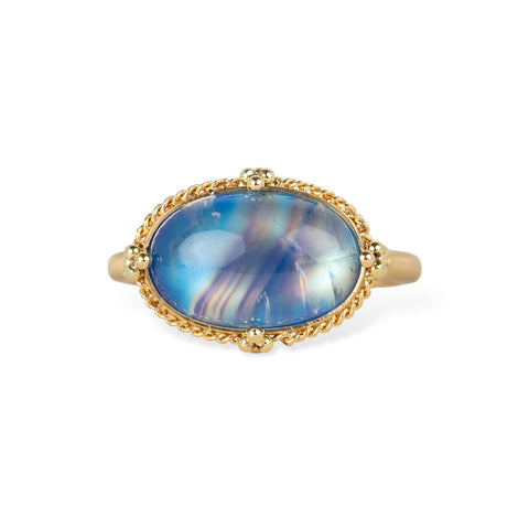 Gold ring with a moonstone on a white background