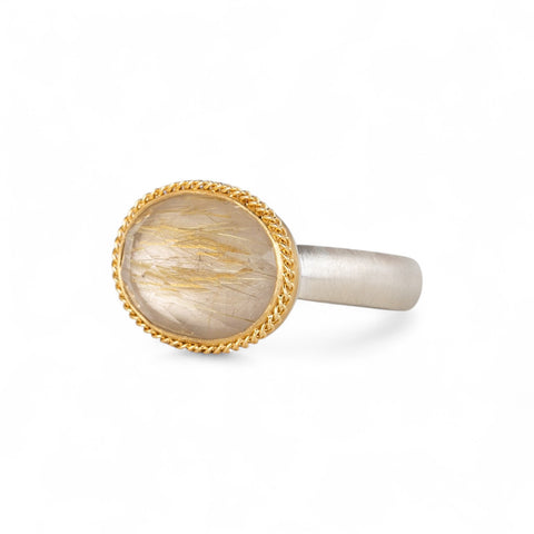 Ring with rutilated quartz stone with an 18k gold bezel and sterling silver band