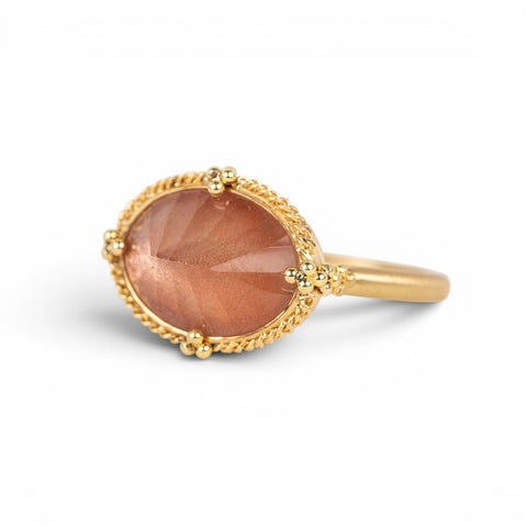 Gold ring with an Oregon sunstone on a white background