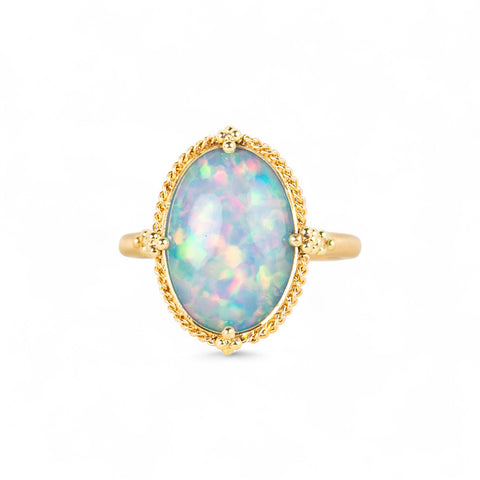 Gold ring with an Ethiopian opal stone on a white background