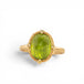 Gold ring with a peridot gemstone on a white background