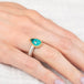 Silver and gold ring with a peruvian opal stone on a hand against a light background