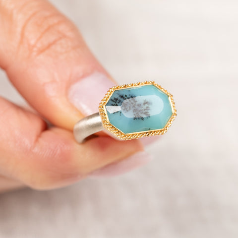 Gold and silver ring with peruvian opal stone held in hand