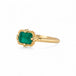 Gold ring with an emerald gemstone on a white background