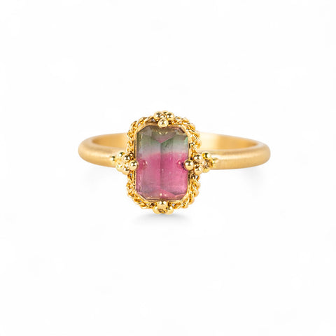 Gold ring with a watermelon tourmaline gemstone on a white background