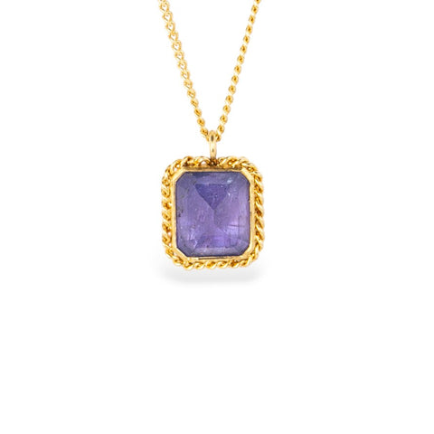 Gold necklace with a tanzanite gemstone pendant on a white background
