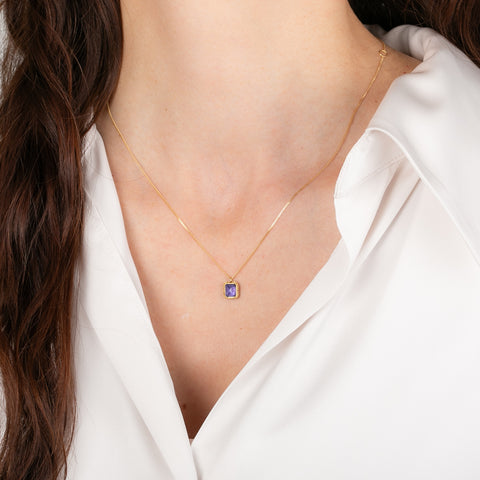Gold necklace with a tanzanite pendant on a person
