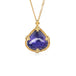 Tanzanite pendant on a gold chain against a white background