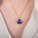 Tanzanite pendant on a gold chain against a person