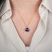 Tanzanite pendant on a gold chain against a person