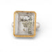 Ring with a gold frame, silver band and quartz with pyrite stone on a white background