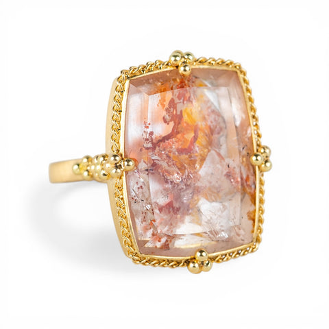 Gold ring with a colorful quartz with pyrite on a white background