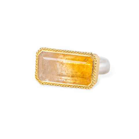 Gold and silver ring with a rectangular citrine stone on a white background