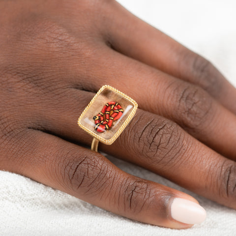 Gold ring with lodolite stone featuring snake design on a person's finger