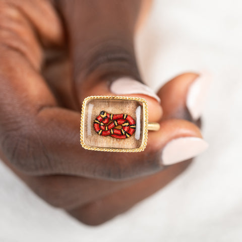Gold ring with lodolite stone featuring snake design held in hand