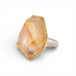 Ring with a large rutilated quartz stone on a white background