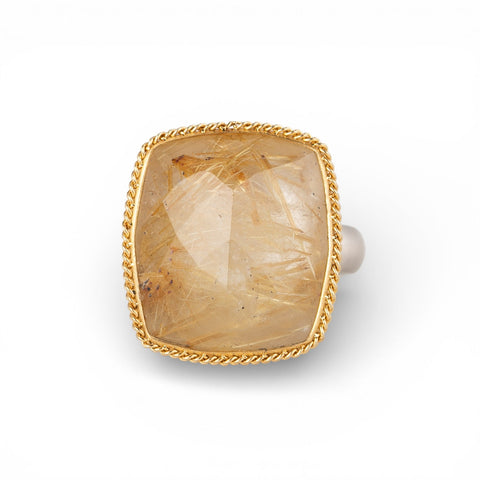 Gold and silver ring with a rutilated quartz stone on a white background