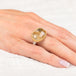 Ring with a gold bezel, silver band and rutilated quartz stone on a hand