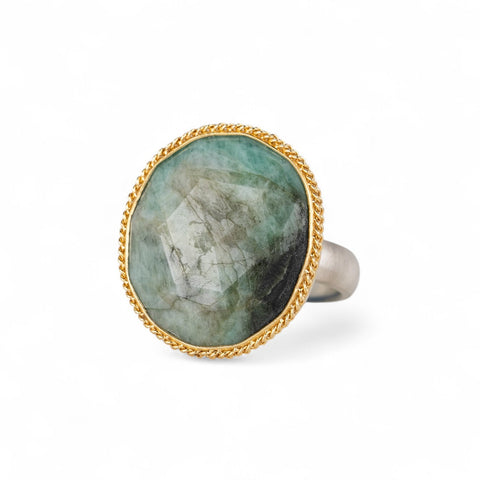 Emerald ring with a gold bezel and sterling silver band