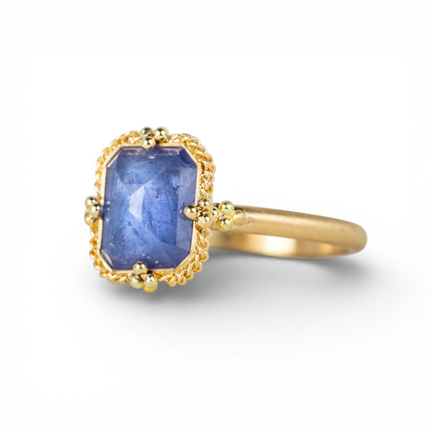 Gold ring with a tanzanite gemstone on a white background