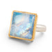 Gold and silver ring with a square moonstone on a white background