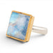 Gold and silver ring with a square moonstone on a white background