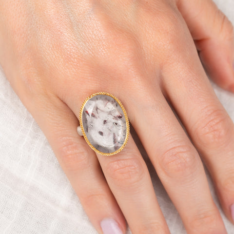 Gold and silver ring with a super 7 stone on a hand