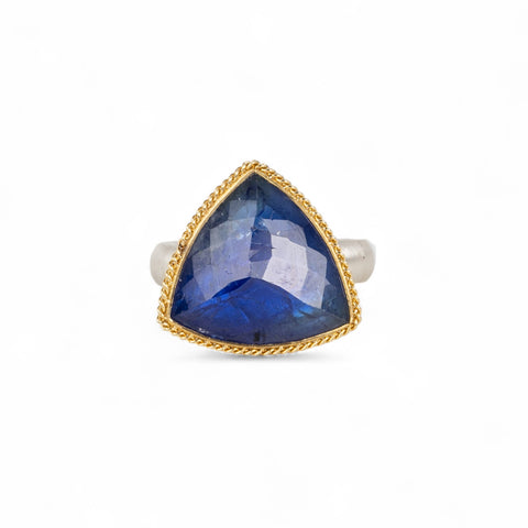 Handmade ring with a tanzanite gemstone, gold bezel and sterling silver band on a white background