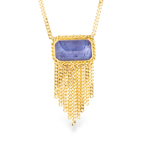 Gold necklace with a tanzanite gemstone pendant on a white background