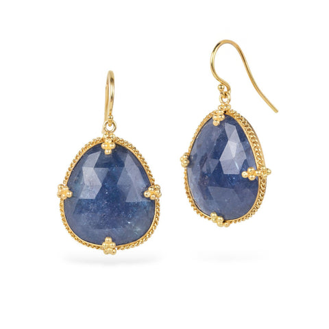 Pair of gold earrings with blue tanzanite gemstones on a white background