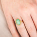 Gold ring with an Ethiopian opal gemstone on a hand
