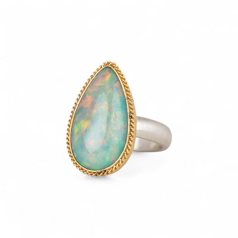 Ethiopian opal teardrop ring with gold bezel and silver band
