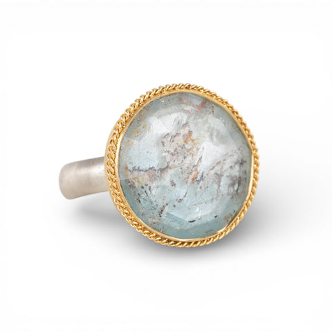 Silver and gold ring with topaz stone on a hand