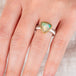 Hand wearing an Ethiopian opal ring with 18k gold bezel and sterling silver band