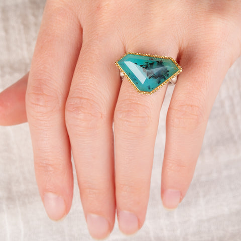 Hand wearing a Peruvian opal ring with gold bezel and sterling silver band