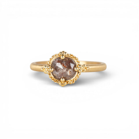 Gold ring with a brown diamond on a white background