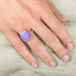 Gold ring with a purple boulder opal stone on a hand